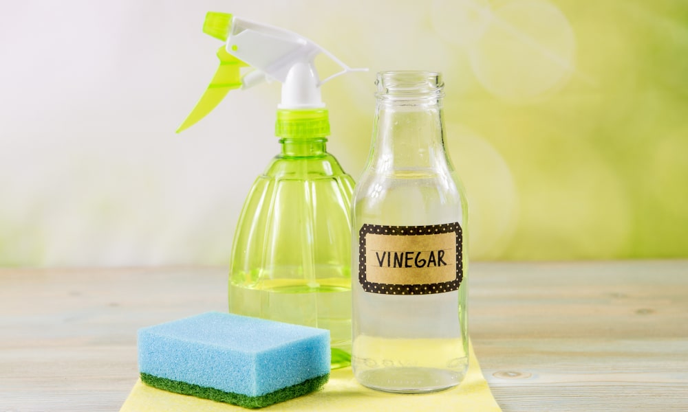 Can vinegar or rubbing alcohol effectively clean sticker residue from windows?