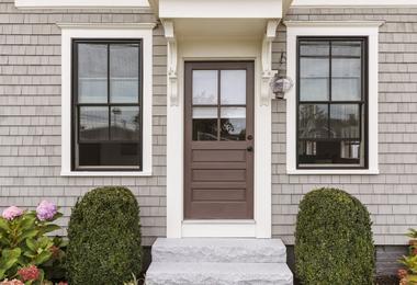 Brown-framed front windows and entry door enhancing a modern home exterior