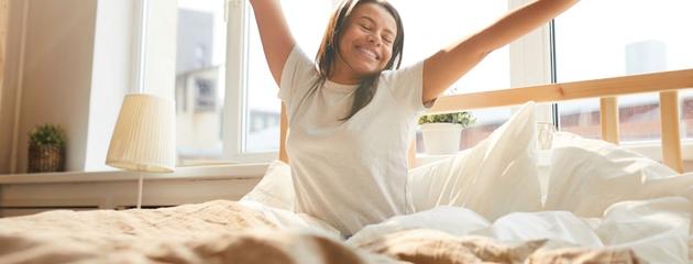 Woman enjoying morning sunlight in an energy-efficient Passive House home
