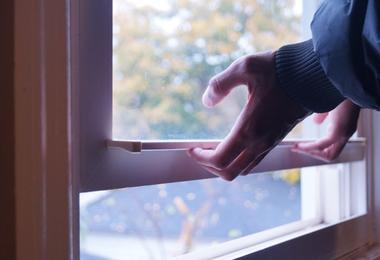 Hand holding a window pane, showing the edge where spacers are located