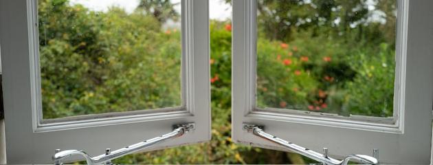 Chrome window handles with built-in window restrictors on an ajar window