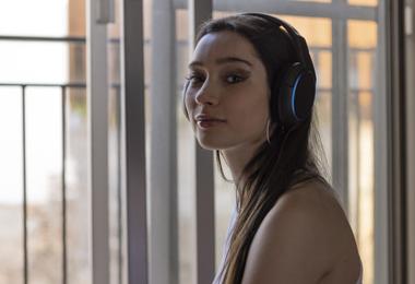 Woman relaxing and listening to music near a soundproof window