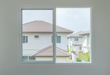 Modern interior with a large window frame comparing casement and sliding window styles