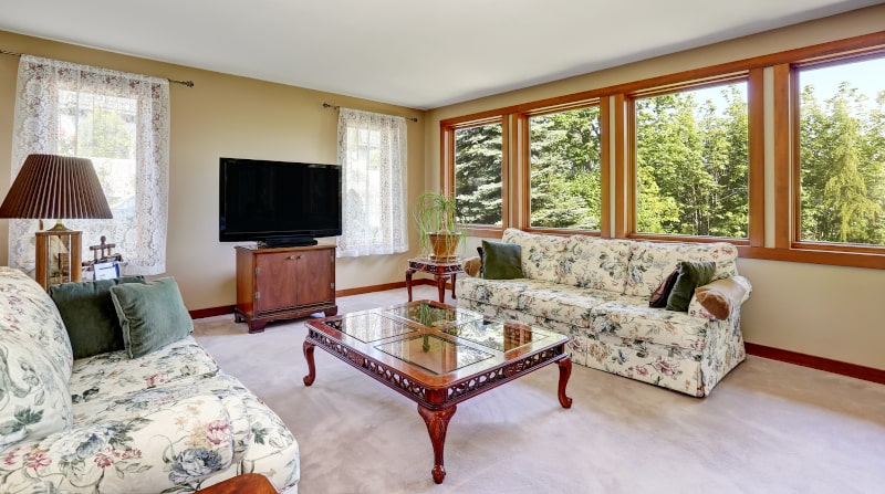Traditional living room with brown-framed windows and warm-toned décor