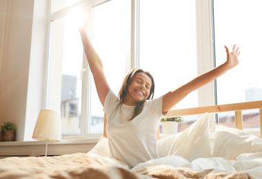 Woman enjoying morning sunlight in an energy-efficient Passive House home