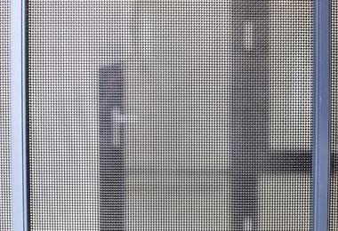 Close-up of a storm door showing weatherstripping and glass panel