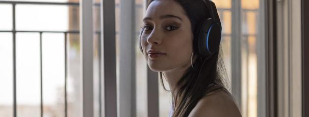 Woman relaxing and listening to music near a soundproof window