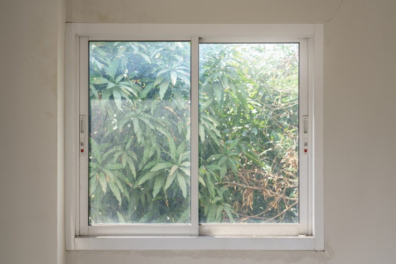White-framed sliding glass window partially open