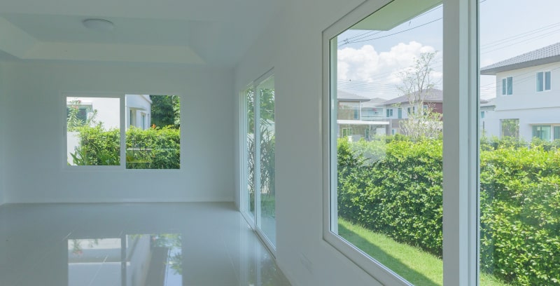 Sunlit room with large impact glass window and wooden flooring