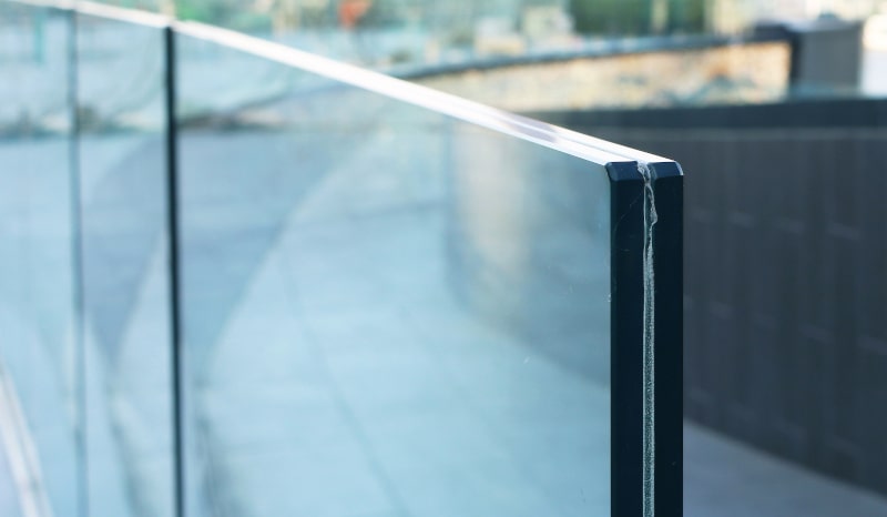 Laminated glass railing on home exterior, showing modern use of safety glass