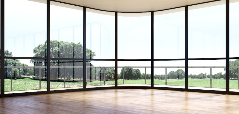 Large luxury modern living room interior with floor-to-ceiling glass walls and bright natural light