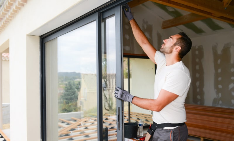 Professional window installer fitting a bay window in a modern Canadian home