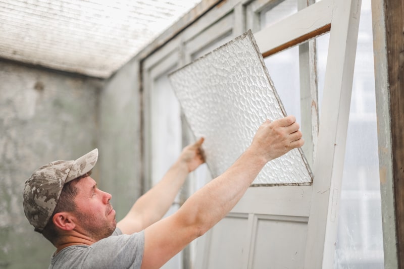 Technician removing glass from an old wooden door for safe recycling in Canada
