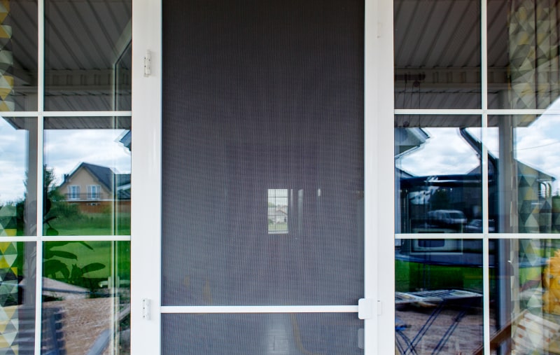 Retractable mosquito screen door on a residential entryway