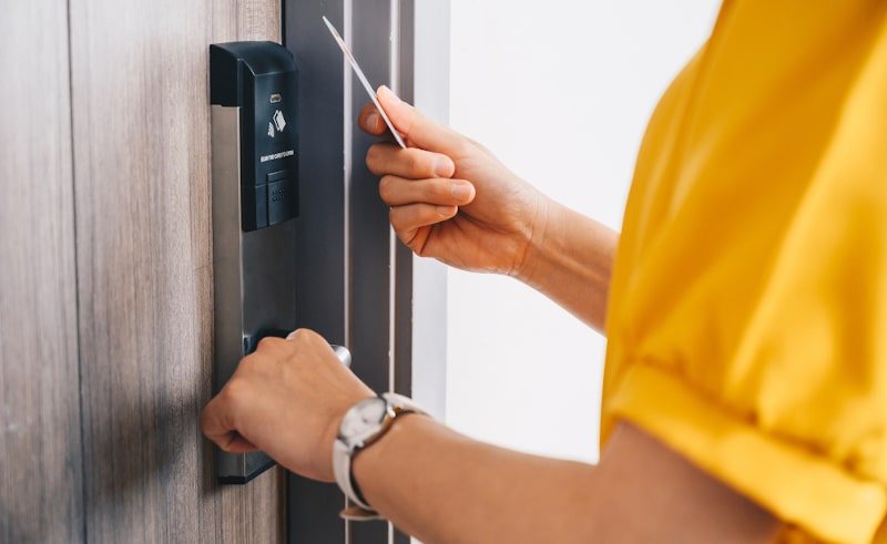 Woman unlocking a smart entry door using a keycard
