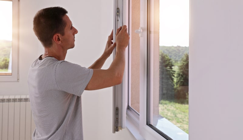 Contractor installing new vinyl windows in an Ontario house
